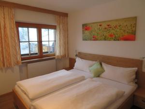 ein Schlafzimmer mit einem Bett in einem Zimmer mit einem Fenster in der Unterkunft Haus Moosbrunn in Alpbach