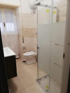 ローマにあるSan Pietro & Trastevere Homeのバスルーム(トイレ、ガラス張りのシャワー付)