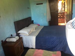 sypialnia z dużym łóżkiem i drewnianą komodą w obiekcie Casa finca típica the lake hotel w mieście Guatapé