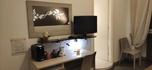 einen Schreibtisch mit einem TV an der Wand in der Unterkunft OneTime Roma in Rom