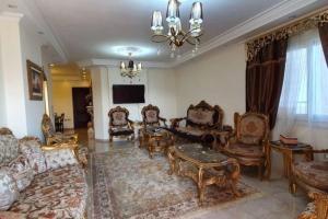 a living room filled with furniture and a chandelier at Charming sunset,Panoramic Nile view & pyramid view in Cairo