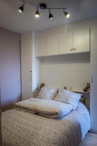 a bedroom with a large bed with white cabinets at les terrasses2 in Ostend