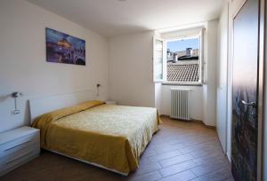 una piccola camera da letto con un letto e una finestra di Residence SANTABBONDIO a Como