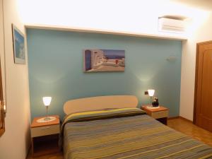 1 dormitorio pequeño con 1 cama y 2 lámparas en Aparthotel Feeling at Home, en Castenaso
