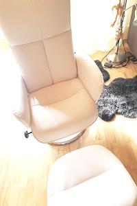 a white chair in a living room with a rug at Haus Sonnenhang in Lam