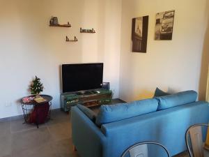 un soggiorno con divano blu e TV di La casetta di Anastasia a Roma