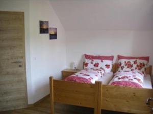 a bedroom with a wooden bed with pillows on it at Urlaub am Bauernhof Höbarten in Sankt Anton an der Jessnitz