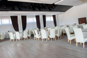 a room filled with white chairs and a table at Complex Noblesse in Vaslui