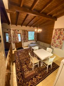 Persey Villa Borovets في بوروفتس: غرفة معيشة مع طاولة وكراسي بيضاء