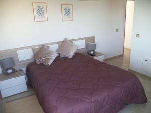 1 dormitorio con 1 cama grande y edredón morado en Quartos Maria Clara, en Sagres