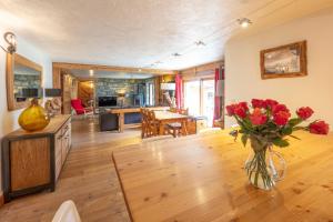 ein Wohnzimmer mit einer Vase mit Blumen auf einem Tisch in der Unterkunft Appartement Marcella in Montgenèvre