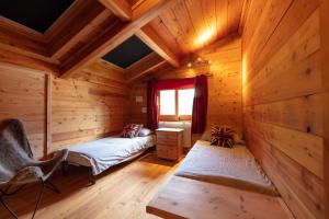 ein Zimmer mit zwei Betten in einer Blockhütte in der Unterkunft Appartement Marcella in Montgenèvre