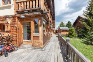 a wooden building with a porch on a deck at Appartement Marcella in Montgenèvre
