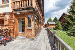 ein Holzgebäude mit einer Veranda auf einer Terrasse in der Unterkunft Appartement Marcella in Montgenèvre