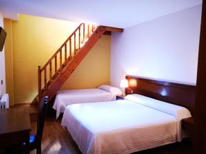 Habitación con 2 camas y escalera. en Hotel Santa Bàrbara De La Vall D'ordino en Ordino