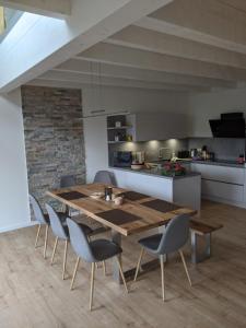 una cucina e una sala da pranzo con tavolo e sedie in legno di Ferienhaus Schieferterrasse - Waldsee Rieden - a Rieden