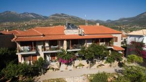 a house with an orange roof and trees and mountains at Skafidakia in Agios Nikolaos