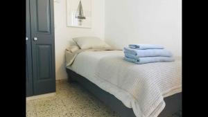 Un dormitorio con una cama con toallas azules. en 1 person Sea View Studio, en la escalera de San Andres, en Santa Cruz de Tenerife