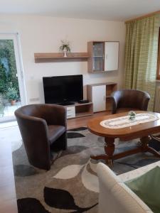 a living room with a table and chairs and a television at Ferienwohnung Viktoria in Lenzkirch