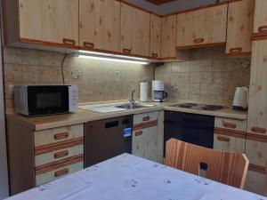 a kitchen with wooden cabinets and a sink and a microwave at Ferienwohnung Viktoria in Lenzkirch