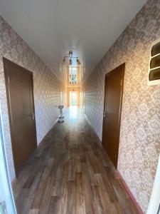 an empty hallway with two doors and wood floors at Hotel Olympia in Adler