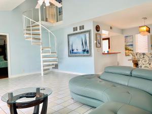a living room with a couch and a spiral staircase at Beach House in Clearwater Beach