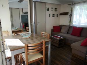 sala de estar con mesa y sofá en Meublé de tourisme 6/8 pers bord de mer sur camping 4*, en Vias