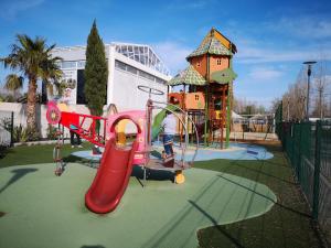 un niño jugando en un tobogán en un parque infantil en Meublé de tourisme 6/8 pers bord de mer sur camping 4*, en Vias