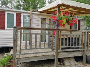 een huis met een terras met bloemen erop bij Meublé de tourisme 6/8 pers bord de mer sur camping 4* in Vias