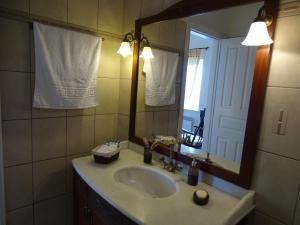 bagno con lavandino e specchio di Villa ADA a Hydra