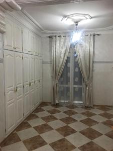 Habitación con armarios blancos y suelo a cuadros. en Super appartement de luxe T4 a la ville de Bejaia, en Bugía