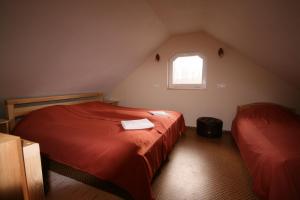 a attic bedroom with two beds and a window at Meža Salas in Lāde