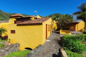 a yellow house with a stone path in front of it at Casa emblemática in Tegueste
