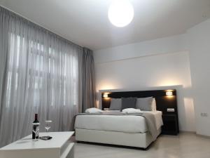 1 dormitorio con cama y mesa con copa de vino en Boss Boutique Athens, en Atenas