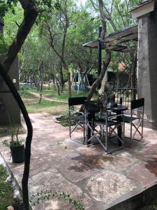 een patio met een tafel en stoelen in een park bij Cabañas Apart Margaridas in Merlo