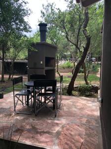 a patio with a stove and a table and chairs at Cabañas Apart Margaridas in Merlo