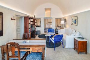 a living room with a white couch and blue chairs at De Profundis by Thireon in Oia