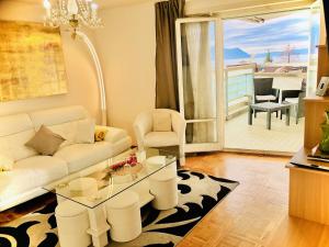 sala de estar con sofá blanco y mesa de cristal en Lake & Mountain View Apartment I 27, en Montreux