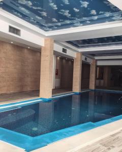 a swimming pool in a hotel with a blue ceiling at Studio Apartment Station Kopaonik,Milmari Resort in Kopaonik