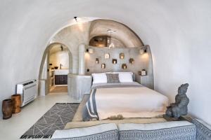 ein Schlafzimmer mit einem großen Bett und einer gewölbten Decke in der Unterkunft Satori Caves by Thireon in Oia
