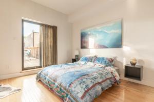 a bedroom with a bed and a large window at Gorgeous Park House w Parking on Queen West in Toronto