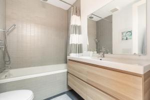 a bathroom with a sink and a tub and a toilet at Gorgeous Park House w Parking on Queen West in Toronto +47 photos