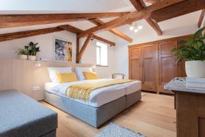 een slaapkamer met een bed in een kamer met houten plafonds bij Ledererhaus in Mauterndorf