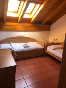 アンダロにあるAppartamenti Al Plozのベッドルーム1室(ベッド2台、天窓付)
