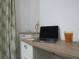 a laptop computer on a desk with a glass of beer at The Tas Suites - Tas Accommodations in Cambridge