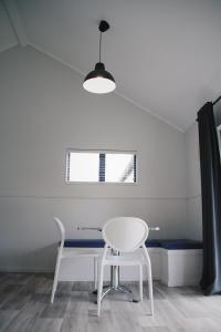 a white table and chair in a room with a window at Hugo & Carters Backpackers & Motel in Tauranga