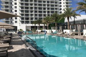 a swimming pool with chairs and a large building at Hollywood Beach luxury condo-HBH in Hollywood
