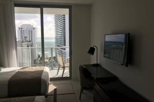a bedroom with a bed and a balcony with a view at Hollywood Beach luxury condo-HBH in Hollywood
