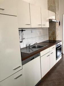 una cocina con armarios blancos y fregadero en Apartment Nanito, en Trogir
