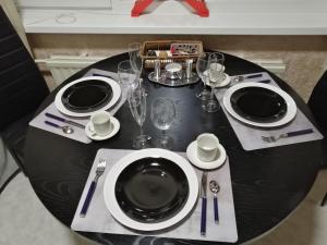 a black table with plates and wine glasses on it at Apartment by the park in Imatra
